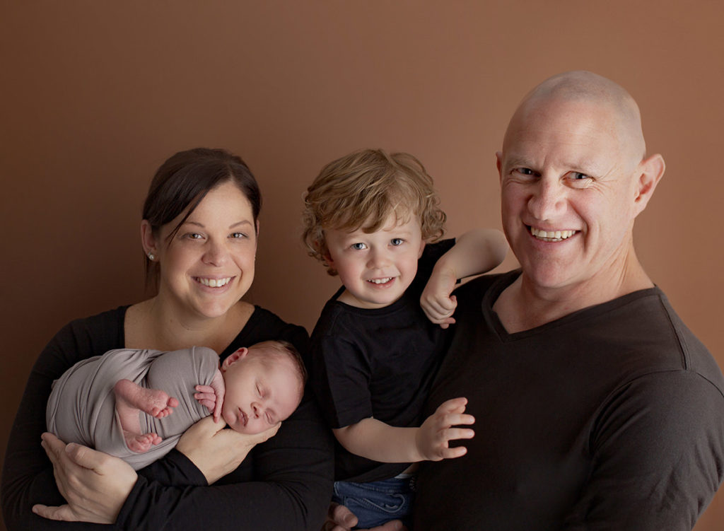 family photo of Jacquline, newborn Elliot, Preston and Daniel